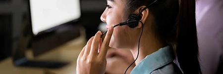 Woman holding headset microphone on left of face